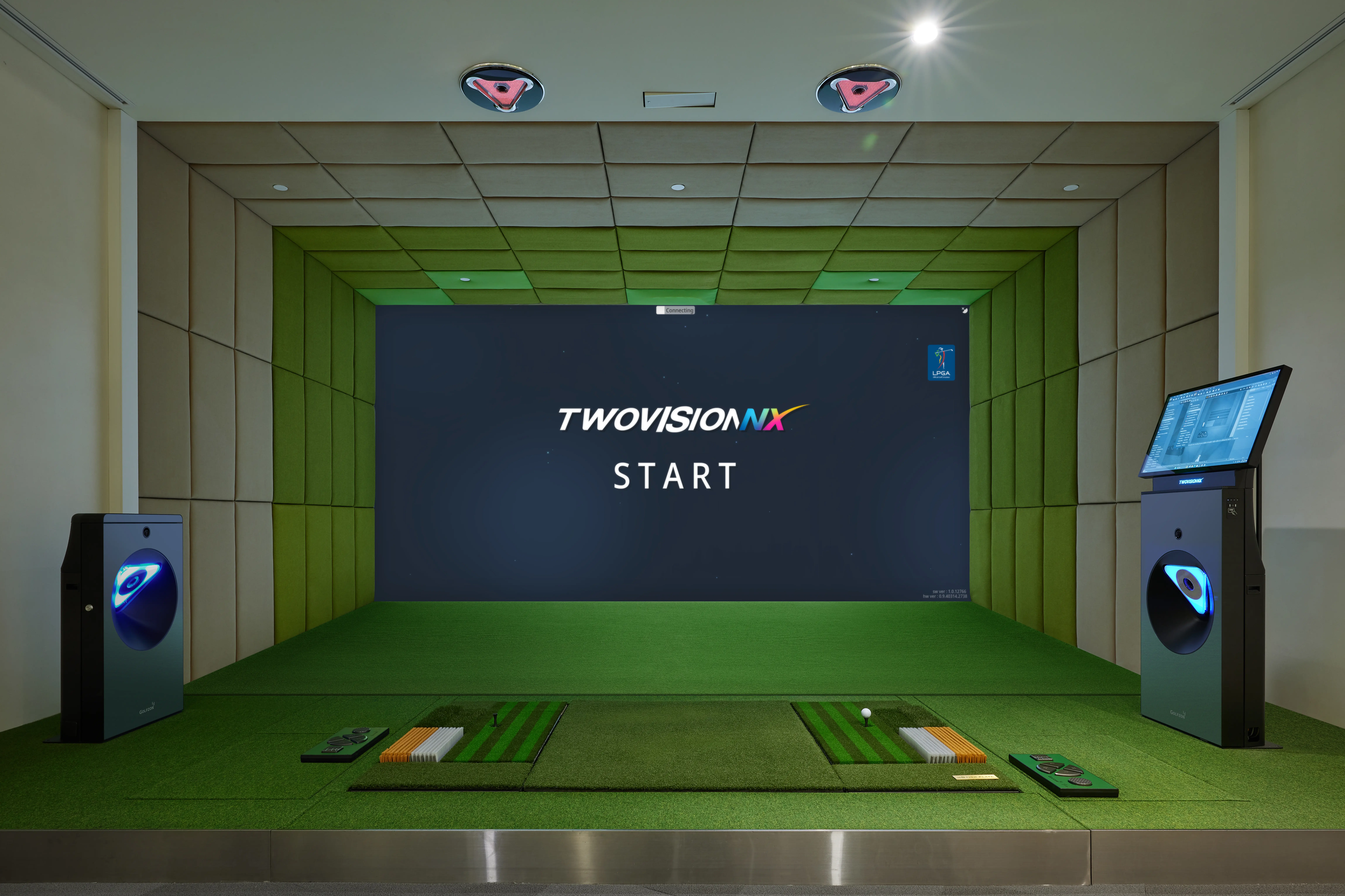A golf club and ball in front of an indoor golf simulator
